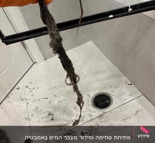 ניקוי סתימה במקלחת עם כלים מקצועיים